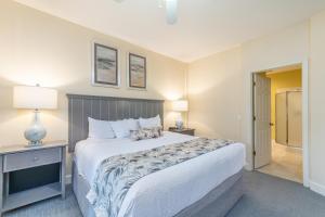 a bedroom with a large white bed and a lamp at Island Links Resort by Palmera in Hilton Head Island