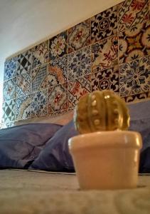 um copo sobre uma mesa com uma parede com azulejos em Donnaciccinatrapani em Rilievo