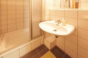 un bagno bianco con lavandino e doccia di bp24 Hotel Aachen ad Aquisgrana