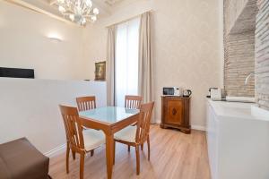a dining room with a table and chairs and a kitchen at Pantheon Escape in Rome