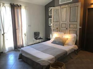 Schlafzimmer mit einem großen Bett mit einem Kopfteil aus Holz in der Unterkunft Villa vue mer in Lumio