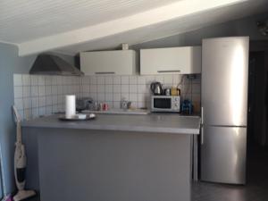 eine Küche mit einem Kühlschrank und einer Mikrowelle in der Unterkunft Villa vue mer in Lumio
