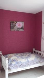 a bedroom with a purple wall with a bed at Gite Halia beauval in Seigy