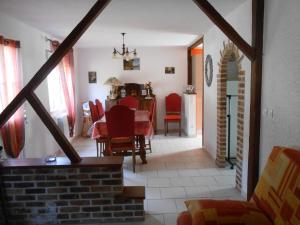 a dining room with a table and red chairs at Gite Halia beauval in Seigy