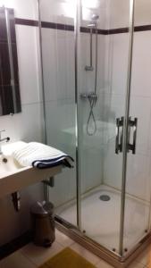 una ducha con una puerta de cristal junto a un lavabo en Le vitrail CHAMBRE Équipée sans service repas, en Yvetot Bocage