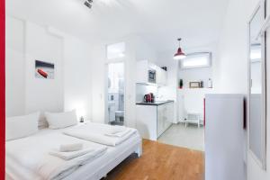 DR APARTMENTS في برلين: غرفة بيضاء مع سرير ومطبخ