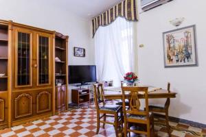 un soggiorno con tavolo, sedie e TV di Casa Lillina a Toledo , near Piazza del plebiscito a Napoli
