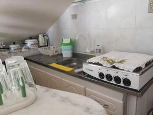 a kitchen with a counter with a stove and a sink at Chalé 01 em Maragogi Brasil Maragogi in Maragogi