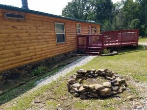 a log cabin with a fire pit in front of it at The Sandstone - A 3BR, 2BA Deluxe Log Cabin in Genoa