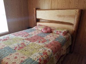 a bedroom with a bed with a quilt on it at The Sandstone - A 3BR, 2BA Deluxe Log Cabin in Genoa