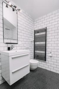 a white bathroom with a sink and a toilet at Hanna's suite with free parking in Ljubljana