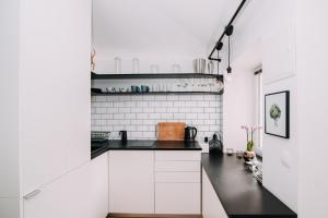 a kitchen with white walls and black countertops at Hanna's suite with free parking in Ljubljana +23 photos