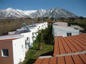 a row of white buildings with mountains in the background at Victory Apartments Hotel in Samothraki
