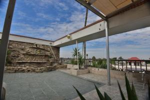 a building with a stone wall and a patio at Bed Bed Hotel Abasolo in Torreón