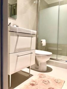 a white bathroom with a toilet and a shower at Petit Rêve in LʼIsle-sur-la-Sorgue