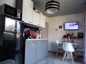 a kitchen with a black refrigerator and a table at Snežak (Snowman) in Bohinj