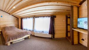 a bedroom in a log cabin with a bed and a window at Guest House Plai in Yaremche +53 photos