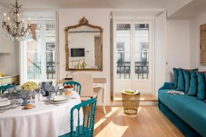 un soggiorno con tavolo e divano blu di Residentas Aurea a Lisbona