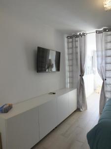 een woonkamer met een tv aan een witte muur bij BLU in Puerto del Carmen