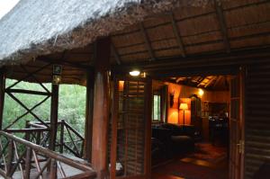 a living room of a house with a thatch roof at Lion Tree Bush Lodge in Marloth Park