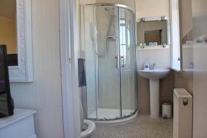 a bathroom with a shower and a toilet and a sink at The Anchorage in Weymouth
