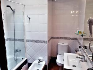 a bathroom with a shower and a sink and a toilet at Hotel las Calas in Agua Amarga +37 photos