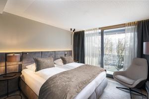 Hotel Riedenburg في باد فسينغ: غرفة نوم بسرير وكرسي ونافذة