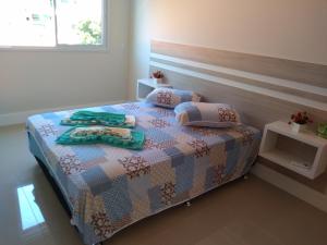 a bedroom with a bed with two towels on it at Ap Praia De Palmas in Governador Celso Ramos