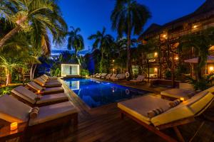 einen Pool mit Liegestühlen und ein Resort in der Unterkunft Magic Blue Spa Boutique Hotel Adults Only in Playa del Carmen
