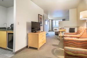 a living room filled with furniture and a tv at Westmark Fairbanks Hotel and Conference Center in Fairbanks