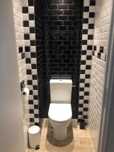 La salle de bains est pourvue de toilettes et de carrelage noir et blanc. dans l'établissement L'Escale Sètoise, à Sète 22 autres photos