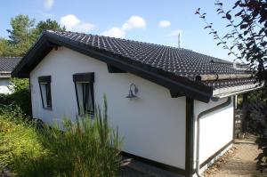 GönnersdorfFerienhaus-4Seasons的一间黑色屋顶的白色小房子