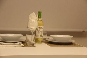 una bottiglia di vino seduta su un tavolo con ciotole di Romantic Loft Ventura a Tarifa Altre 2 foto