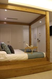 un letto con struttura in legno in una stanza di Romantic Loft Ventura a Tarifa