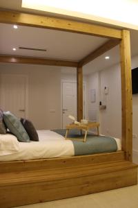 1 cama con marco de madera en una habitación en Romantic Loft Ventura, en Tarifa