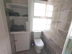 ein Bad mit einem WC und einem Fenster in der Unterkunft Venus 218 flat 4 at Marble Arch in London