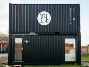 a black shipping container with a bed in it at Containerhus 18b in Harboør