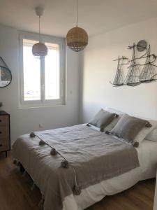 a bedroom with a large bed with two hanging baskets at L'Escale Sètoise in Sète