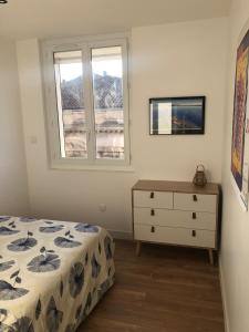 a bedroom with a bed and a dresser and a window at L'Escale Sètoise in Sète