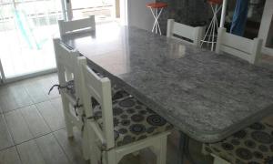 stół jadalny z 2 białymi krzesłami i stołem w obiekcie Un Buen Lugar w mieście Villa Parque Siquiman
