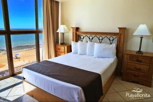 a bedroom with a bed with a view of the beach at Hotel Playa Bonita Resort in Puerto Peñasco