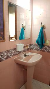 een badkamer met een wastafel en een spiegel bij 2 quartos Praia da Costa in Vila Velha