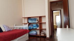 een slaapkamer met een bed en een boekenplank met kussens bij 2 quartos Praia da Costa in Vila Velha