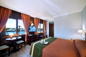une chambre d'hôtel avec un lit, une table et une télévision dans l'établissement Hotel Diego de Almagro Valdivia, à Valdivia