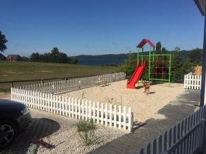 un parco giochi nella sabbia con scivolo rosso di Marina Nadole a Nadole