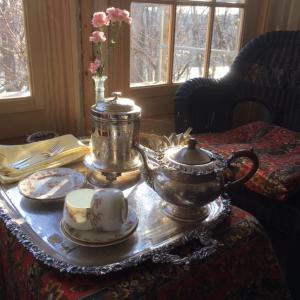 a tea set on a table with a tea pot and cups at The Carriage House Flat - Downtown Paris Canada in Paris