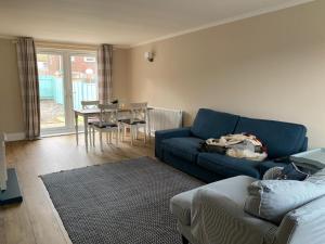 a living room with a blue couch and a table at Newly Renovated & Spacious House in Seahouses