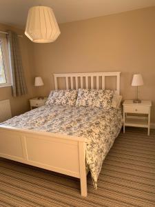 Un dormitorio con una cama grande con dos mesitas de noche. en Newly Renovated & Spacious House, en Seahouses