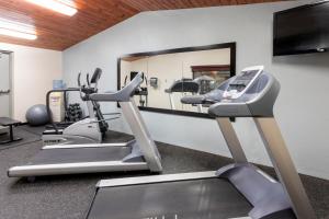 a gym with cardio machines and a mirror at AmericInn by Wyndham Fergus Falls Conference Center in Fergus Falls
