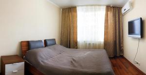 una camera con un letto e una finestra con televisore di Уютный Тихвин апартаменты 1 микрорайон д 50 a Tichvin